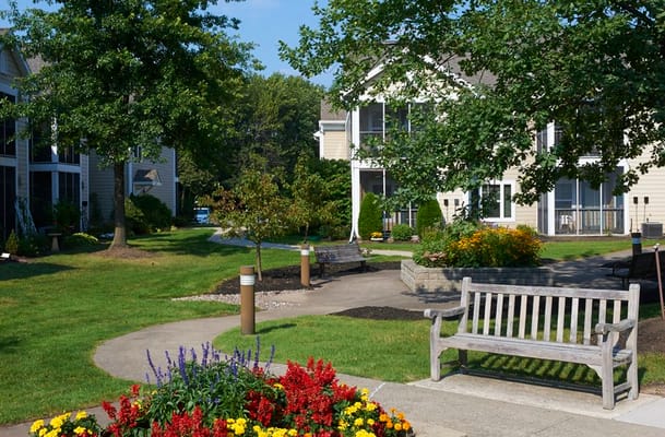 A garden path surrounded by flowers and benches at The Village at Unity.