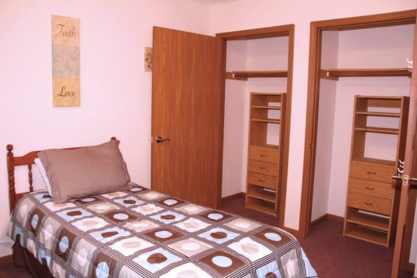 A cozy bedroom with a bed, decorative bedding, and wooden furniture.