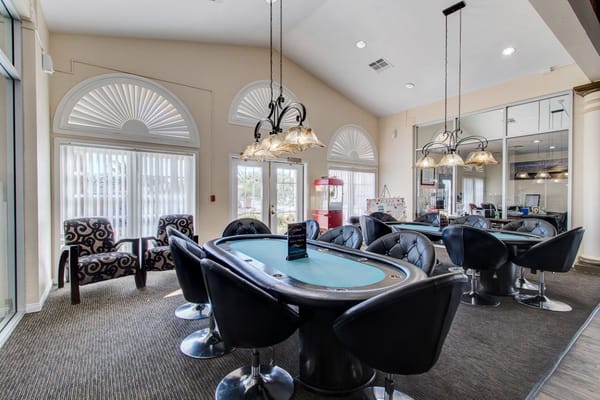 Interior view of the gaming room with poker tables and seating.