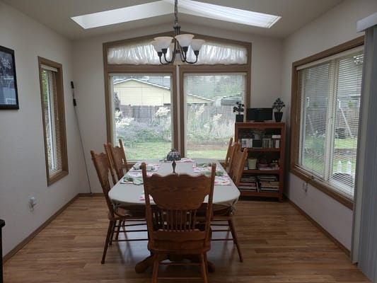 Bright dining room with a large table and wooden chairs
