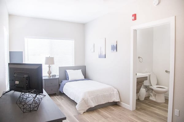 Cozy bedroom with bed, desk, and private bathroom