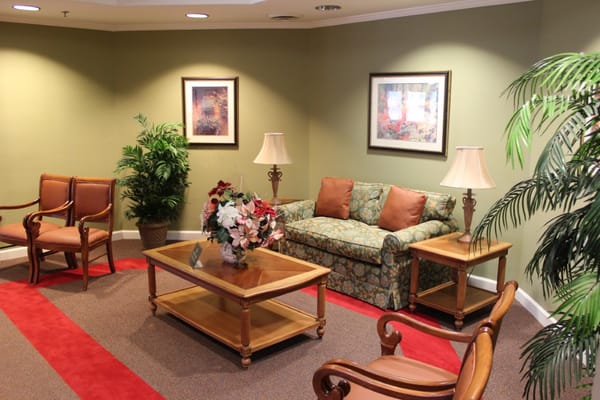 Comfortable living space featuring a floral couch, coffee table, and armchairs.