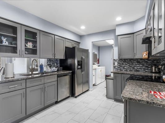 Well-equipped kitchen with granite countertops and modern appliances.
