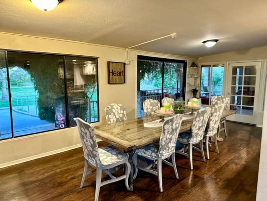 Dining area with a large wooden table and floral chairs