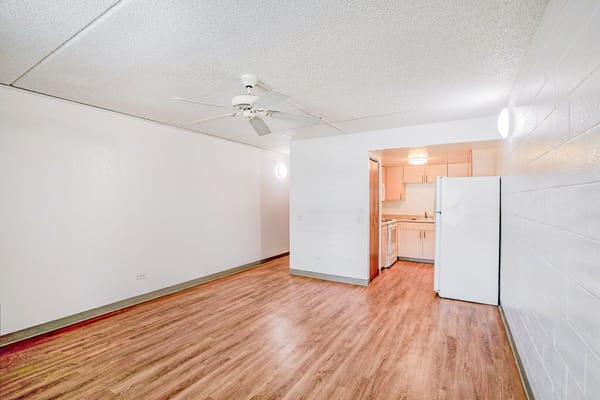 Spacious living room with a ceiling fan and a kitchen area