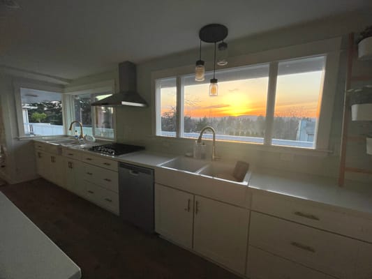 Modern kitchen with a sunset view through large windows