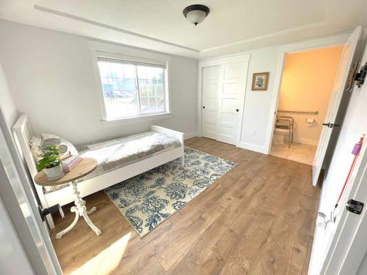 Bright, clean resident room with bed and decor