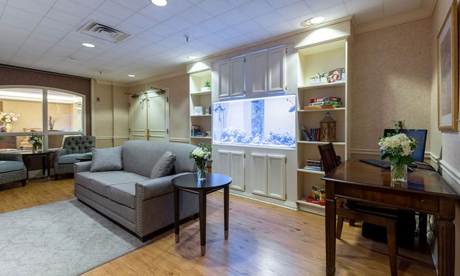 Comfortable seating area with aquarium and bookshelf in a lobby