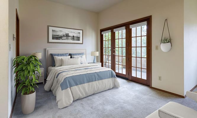 A bright bedroom featuring a bed with blue accents and French doors.