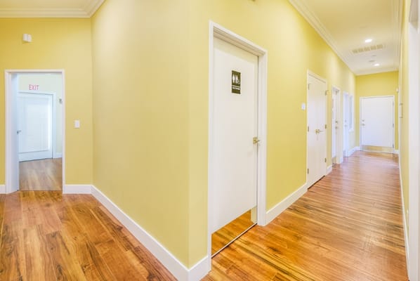 Brightly lit hallway with yellow walls and doors