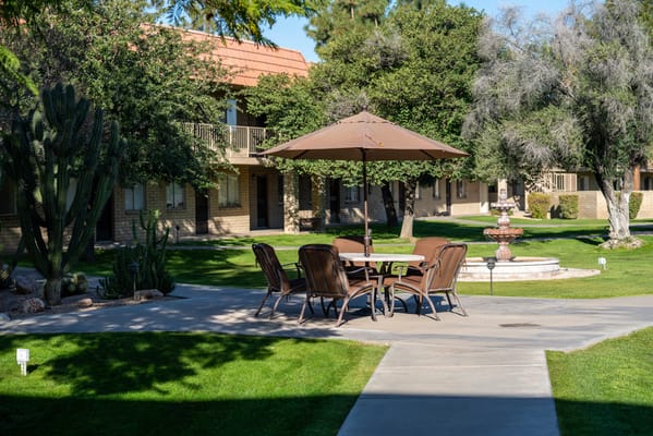 Outdoor seating area with a fountain and landscape