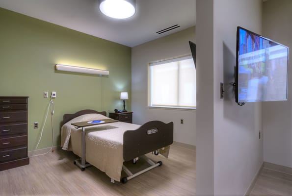 A private resident room with a bed and TV