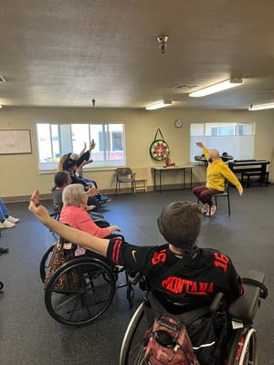 Residents engaging in a seated exercise class