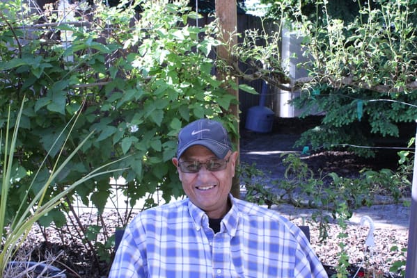 Smiling man sitting in a garden setting