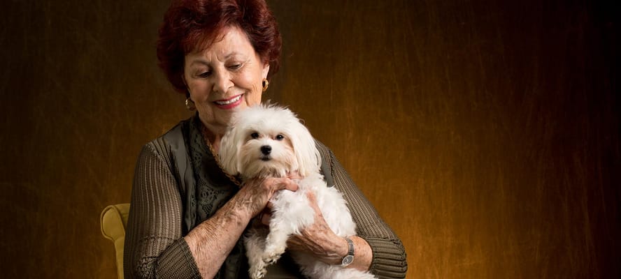 Resident smiling while holding a small dog