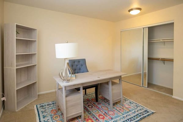 Brightly lit interior of a resident's room with a desk