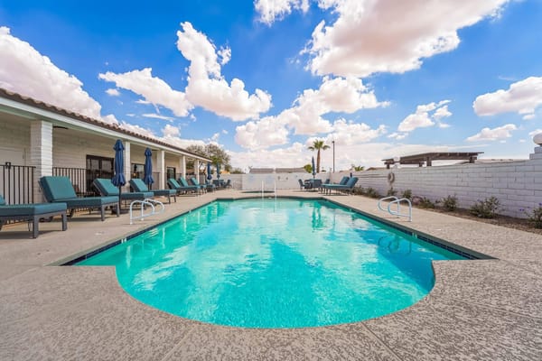 Swimming pool area with lounge chairs and palm trees