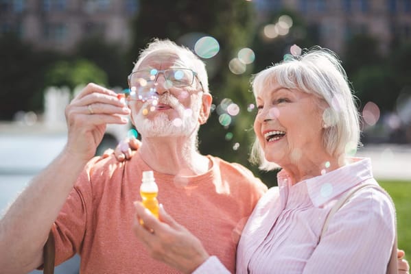 Senior couple enjoying bubble play in the park