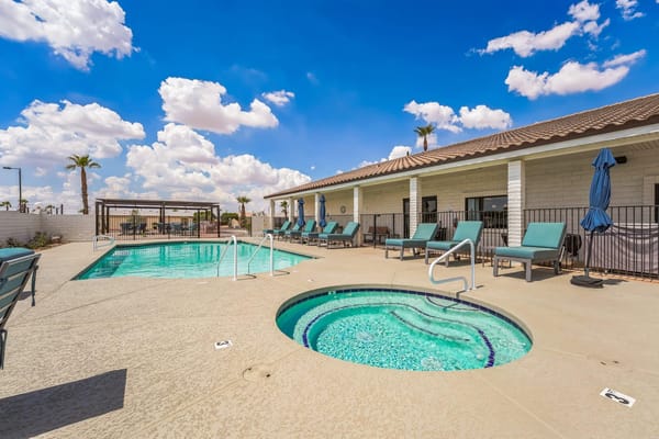 Outdoor pool area with seating and spa