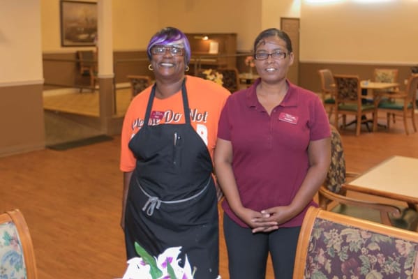 Two staff members posing in the dining area