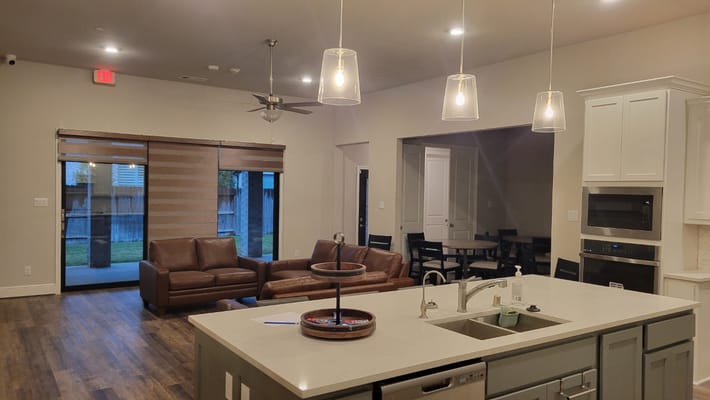 A modern living room with comfortable seating and a kitchen area