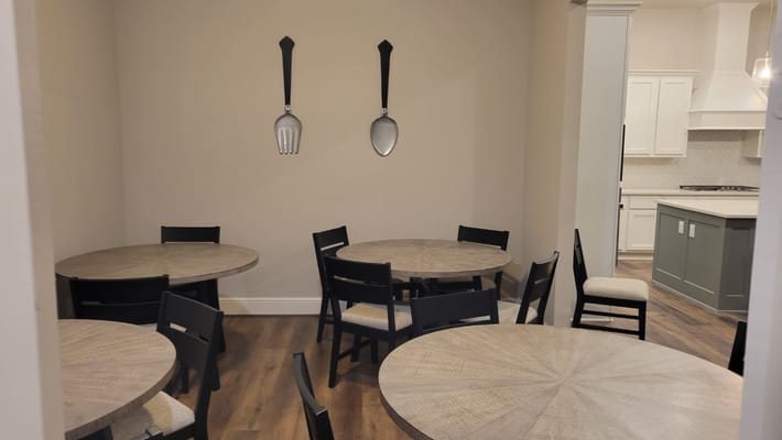 Cozy dining area with round tables and decorative utensils on the wall