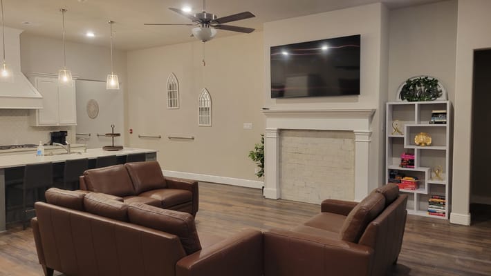 Comfortable living room with leather couches and a television.