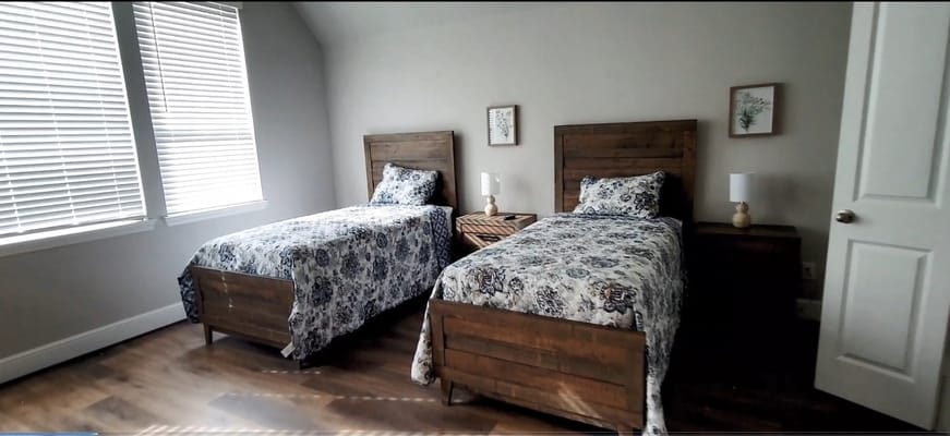 A cozy bedroom with two twin beds and wooden furniture