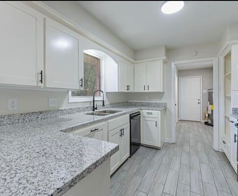 Bright kitchen with granite countertops and stainless steel appliances