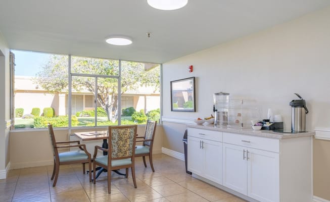 Bright common area with chairs and a view of a garden