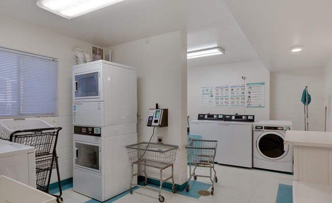 Bright laundry room equipped with washers and dryers.