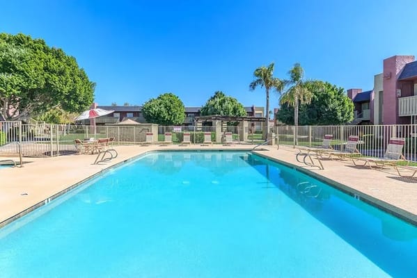 Swimming pool area with lounge chairs and clear sky