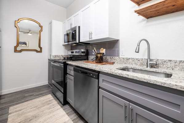 A sleek kitchen with stainless steel appliances and granite countertops.
