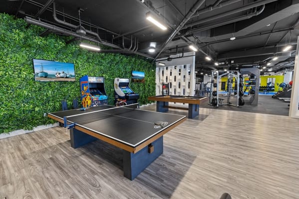 Ping pong tables and arcade games in a vibrant activity room