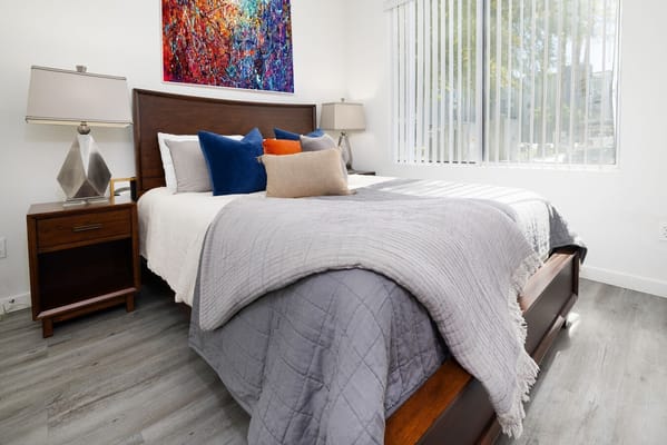 Well-decorated bedroom with a bed, pillows, and lamp.