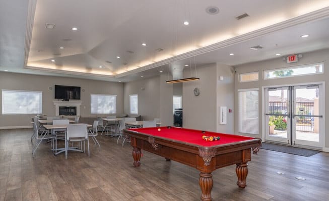 Interior view of the game room with a pool table and seating area