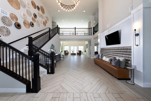Spacious lobby featuring a staircase and decorative wall art.