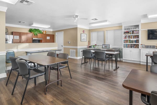 Interior view of the common area with tables and a bookshelf