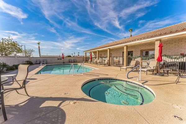 Outdoor pool area with seating and umbrellas