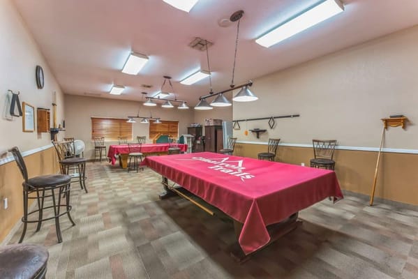 Interior view of a billiards room with tables and chairs