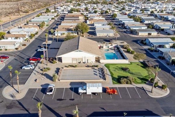 Aerial view of a senior living facility with outdoor pool and parking