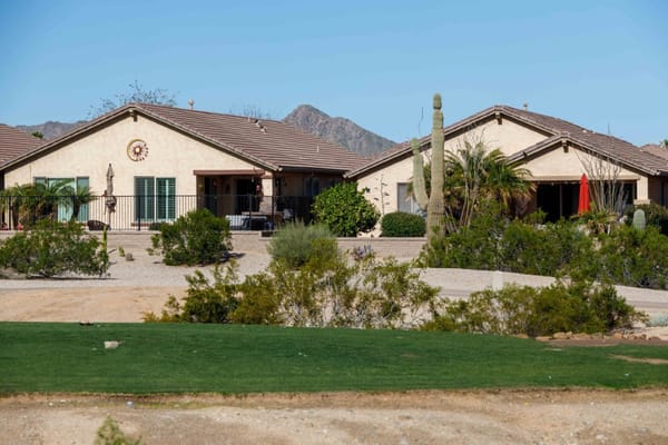 Two residential buildings at Solera at Johnson Ranch surrounded by desert landscaping.