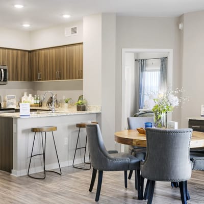 Modern kitchen and dining area with wood accents and seating at Zinc facility.
