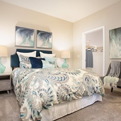 Spacious bedroom with a patterned comforter and decorative pillows