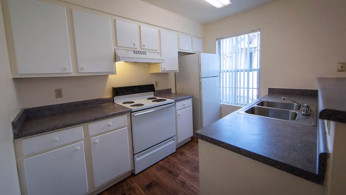 Bright kitchen featuring white cabinets and appliances