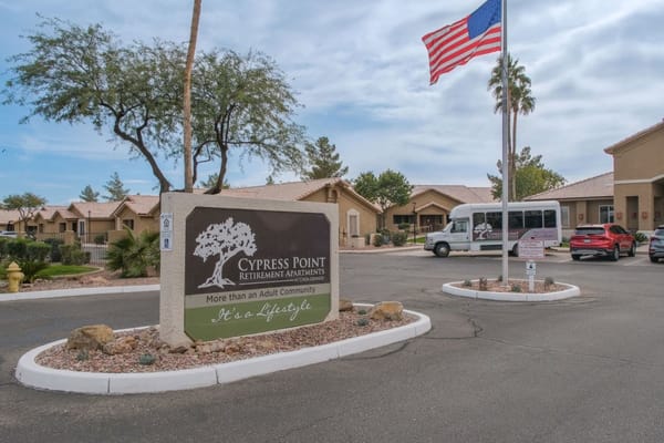 Exterior view of Cypress Point facility with signage and flag