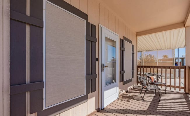 A view of a porch featuring a door and seating area.
