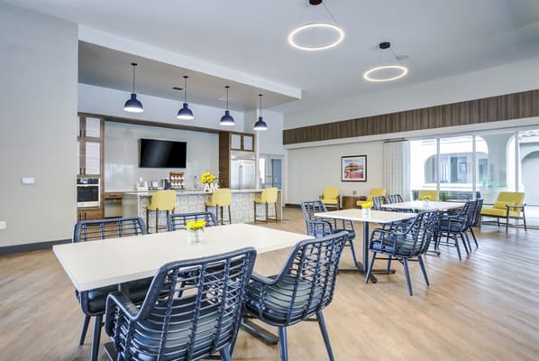 Common area with tables and chairs in a bright room