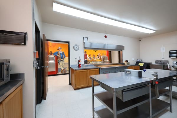 Interior view of the kitchen with stainless steel countertops and colorful mural