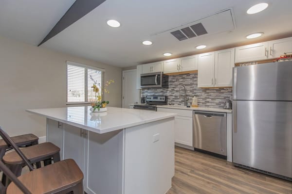 A bright and modern kitchen with stainless steel appliances and a large island.
